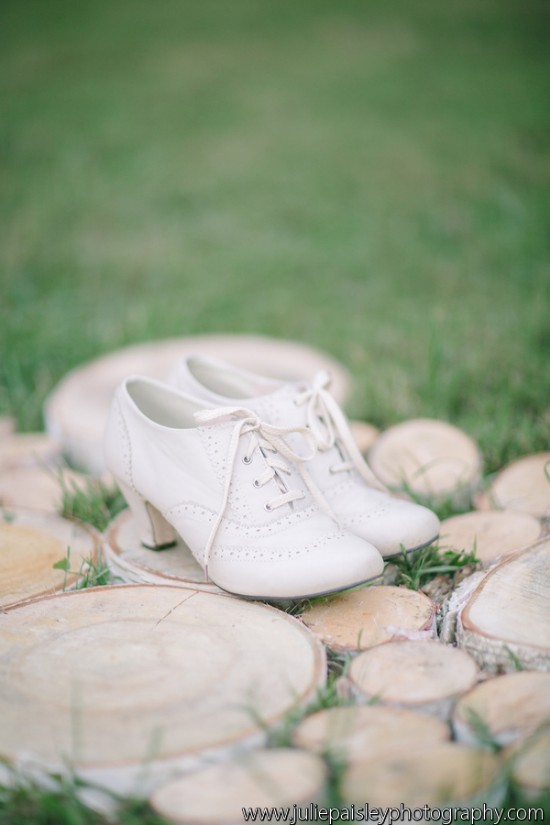 Elegant white wedding shoes on wooden slices outdoors