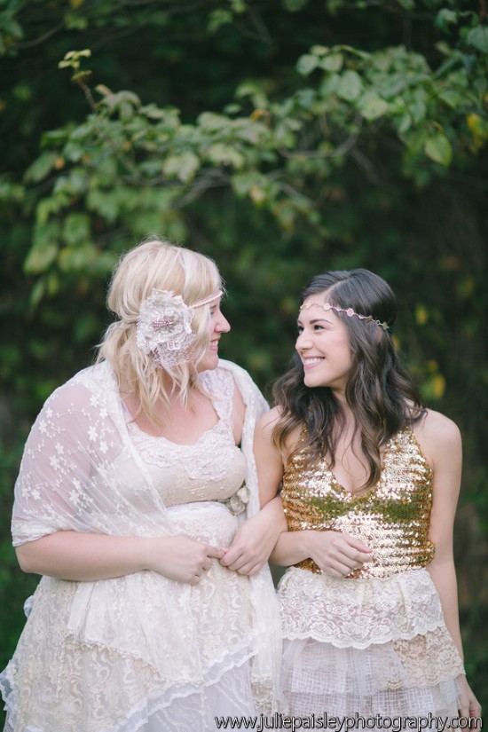 Two smiling women in bohemian attire, embracing each other lovingly