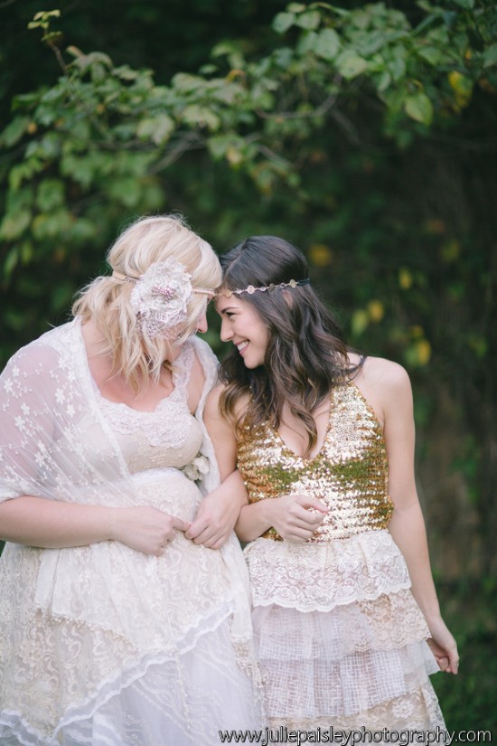 Two women in bohemian dresses smiling in a green setting