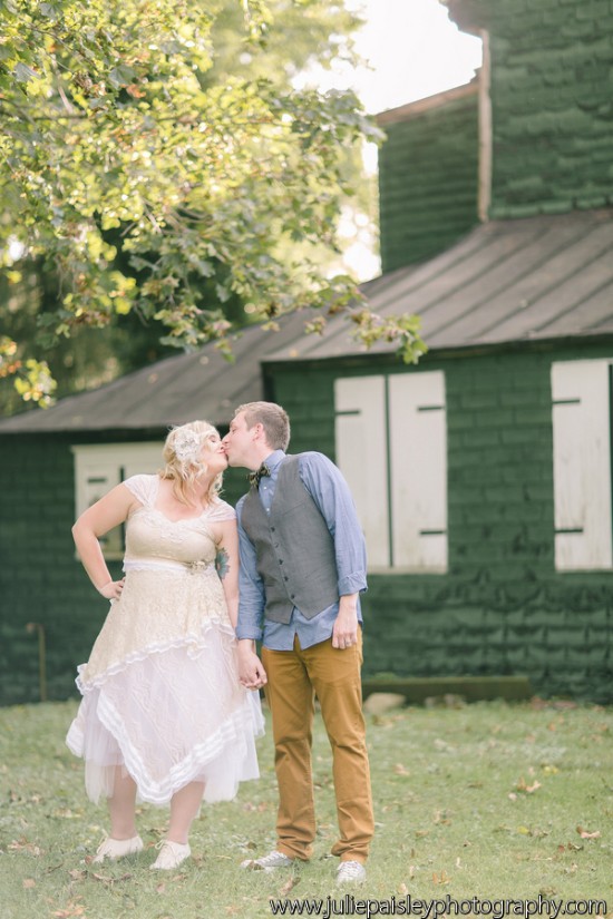 Wedding kiss with vintage dress in front of green house
