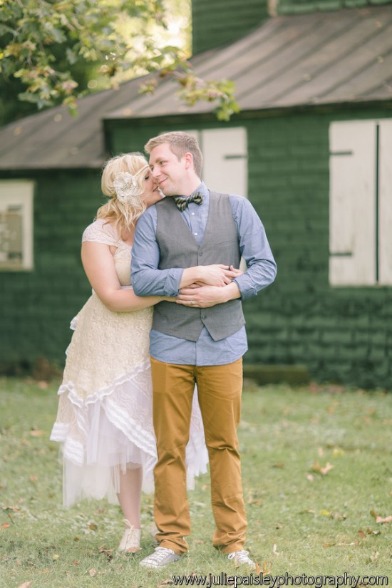 Wedding couple embracing outdoors in rustic setting