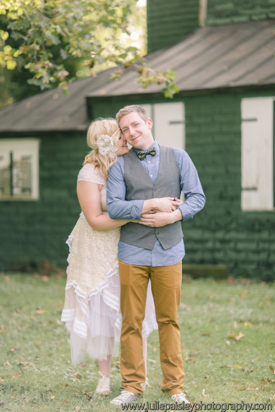 Boho bride embraces groom at outdoor wedding venue