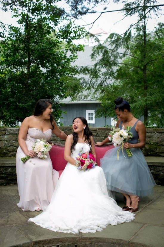 Bride and bridesmaids laughing joyfully on the wedding day outdoors