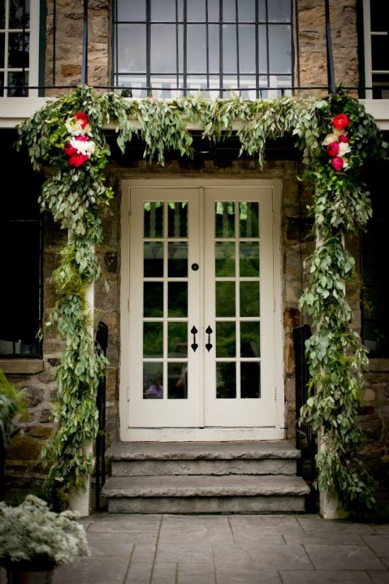 Elegant doorway adorned with greenery and floral arrangements