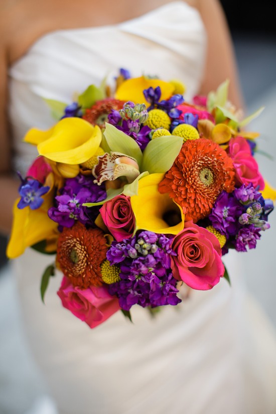 Bride holding a vibrant colorful bouquet of flowers