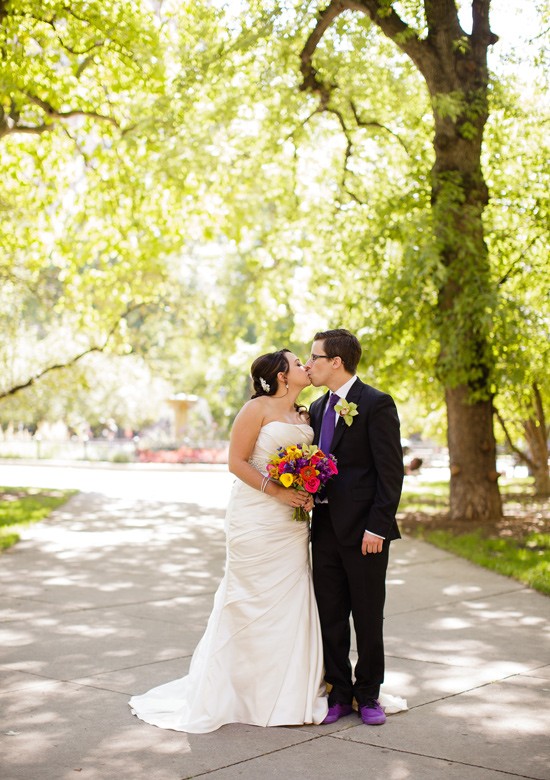 Bride and groom kissing outdoors on wedding day
