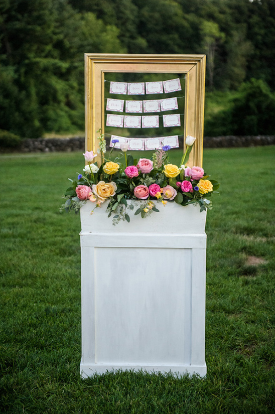 framed hanging escort cards with floral piece