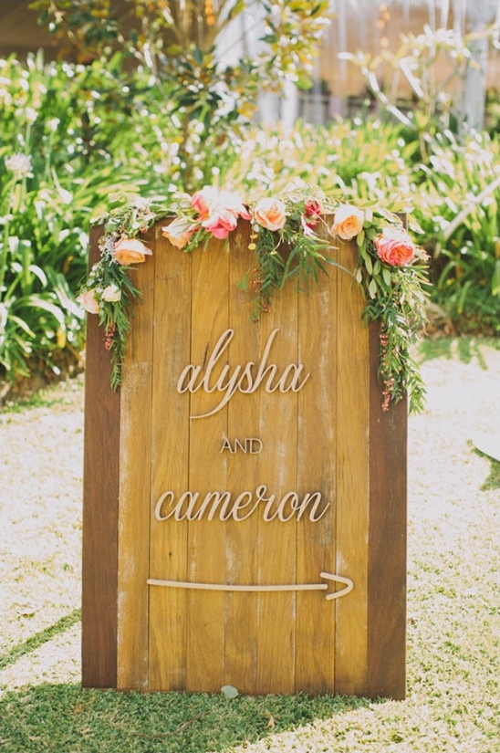 wooden wedding sign drapped in roses