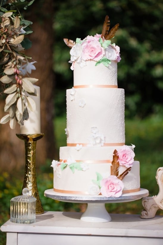 pastel wedding cake with florals and feathers
