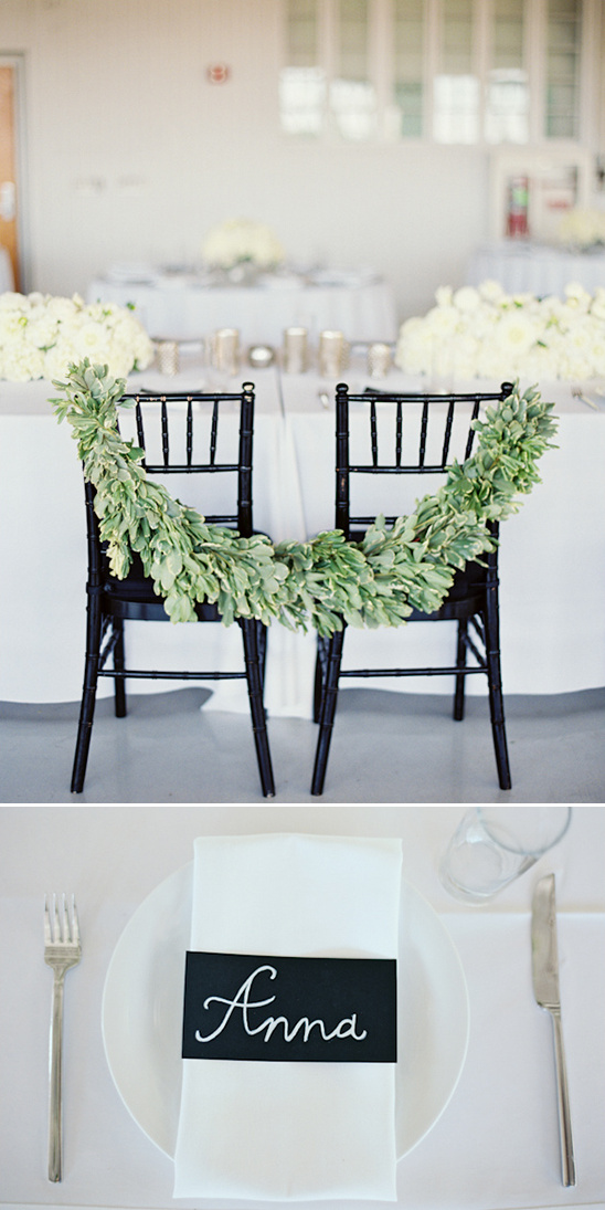 sweetheart seats drapped with greenery garland and chalkboard place cards