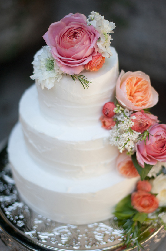 rose and ranunculus topped wedding cake