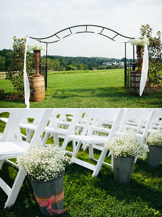 buckets of babys breath and rustic ceremony arch