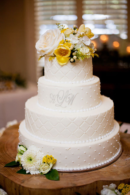 white wedding cake with yellow accent florals