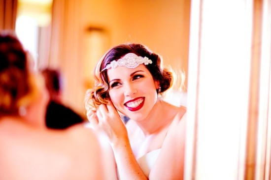 Bride smiling putting on earring vintage hair style