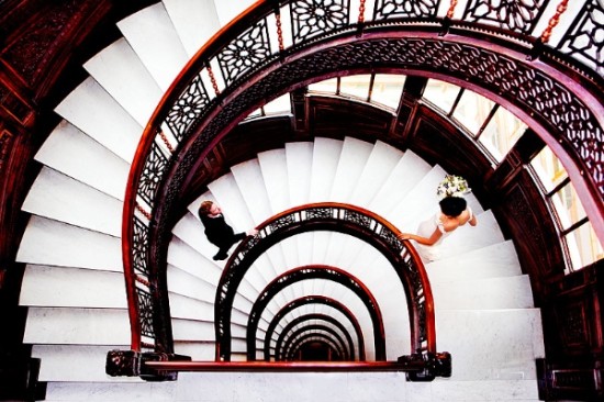 Wedding couple walking down a stunning spiral staircase from above