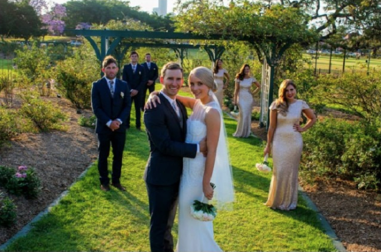 Bride and groom with wedding party in garden setting