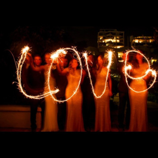 People write love with sparklers at night celebration