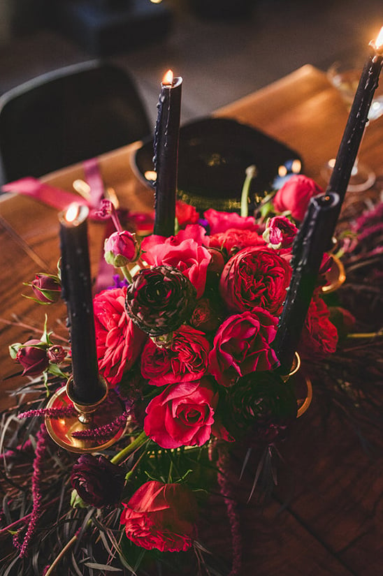 red floral centerpiece with black candles