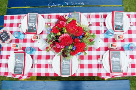 Red and white checkered picnic table setting with flowers