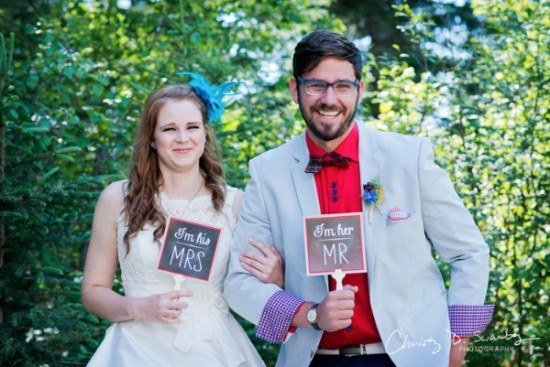 Newlyweds holding Mr and Mrs signs on their wedding day
