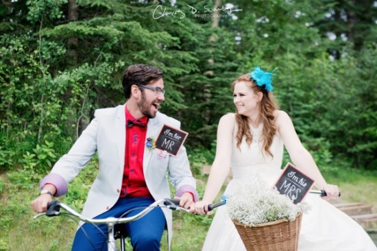 Smiling bride and groom enjoy bike ride on wedding day