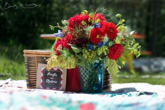 Vibrant red bouquet on picnic blanket with basket