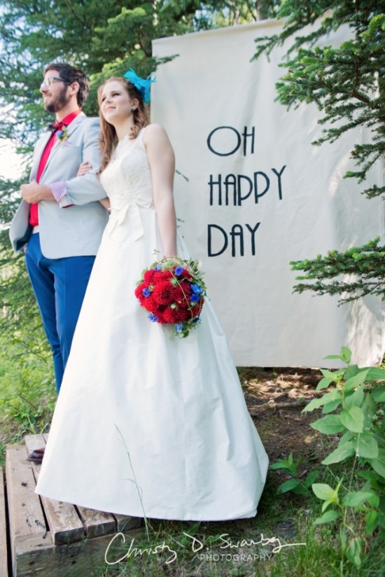 Happy couple at whimsical wedding Oh Happy Day banner