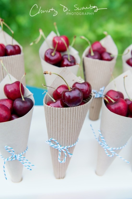 Ripe cherries in paper cones tied with blue string