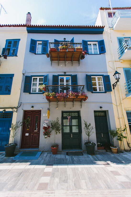 Charming blue shuttered Greek house with flower filled balconies