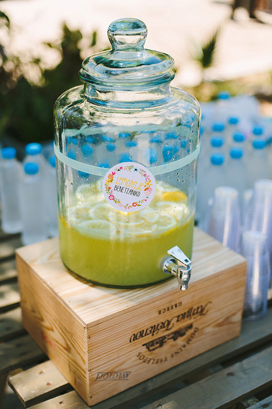Iced lemonade in glass beverage dispenser on wood box