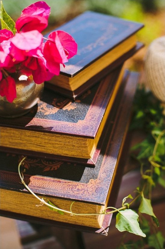 Stack of old books with gold edges and pink flowers
