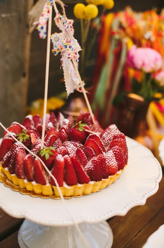 Strawberry tart on a cake stand with party decorations