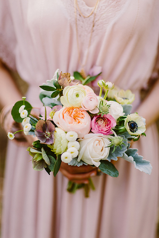 Bride in pink dress holding pastel wedding bouquet