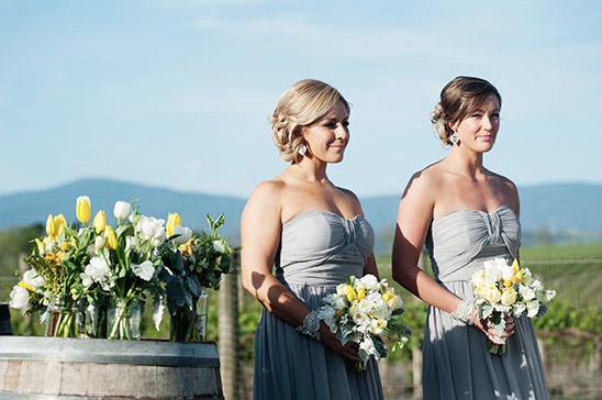 Bridesmaids in grey dresses at vineyard wedding ceremony