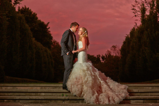 Bride and groom on stairs wedding day sunset sky