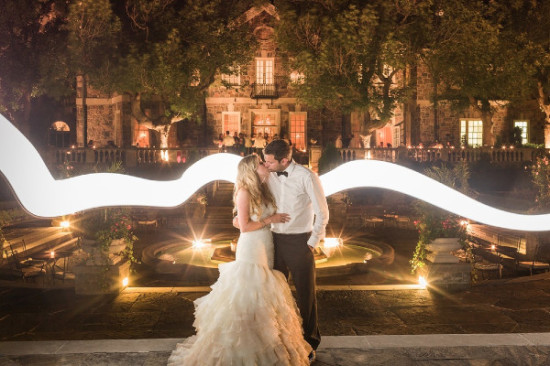 Bride and groom kiss at their outdoor wedding venue