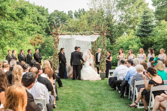 Outdoor wedding ceremony with bride groom and guests