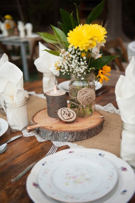 raw wood centerpieces with mason jar floral arrangement
