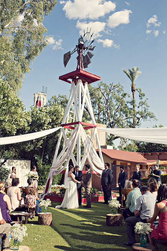 Windmill backdrop at a rustic outdoor wedding ceremony