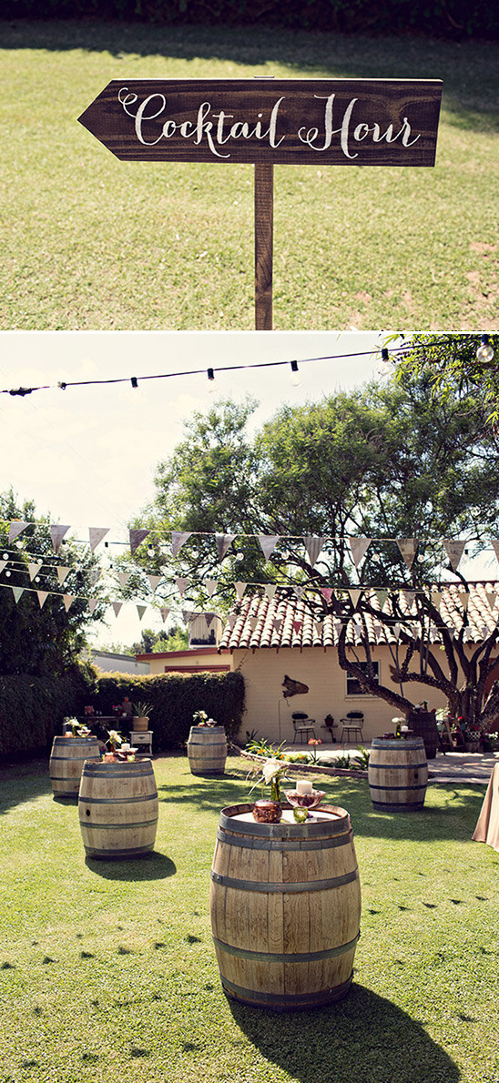 Outdoor wedding cocktail hour with barrel tables and string lights