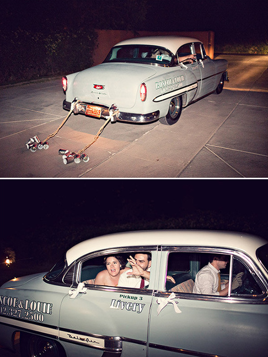 Newlyweds departing in vintage car with cans tied behind
