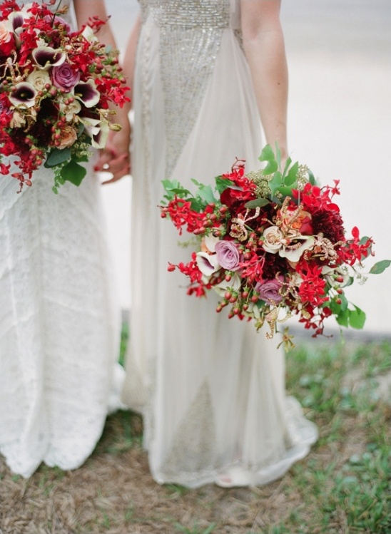 Brides hold vibrant red and purple wedding bouquets