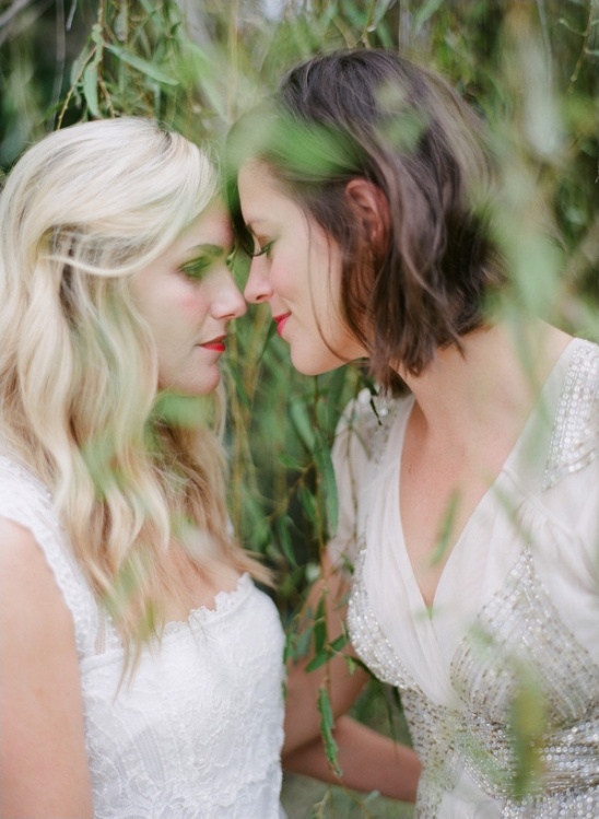 Brides share a loving glance in white dresses outdoors
