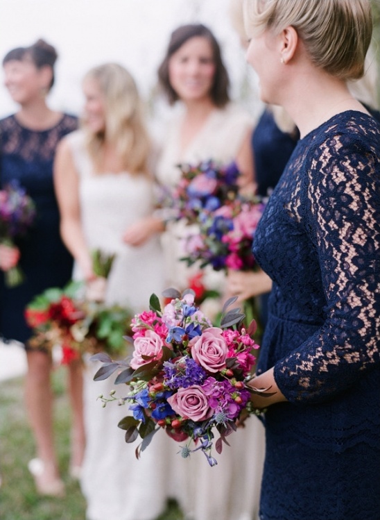 Bridesmaids holding vibrant flower bouquets at wedding