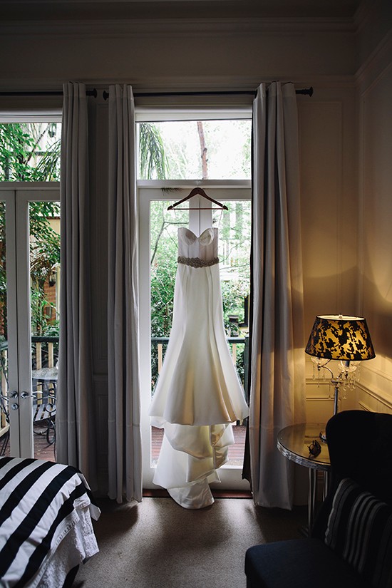 Elegant wedding dress hanging in a sunny room