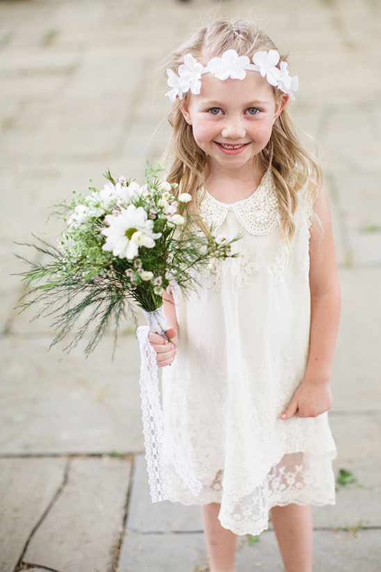 Cute little flower girl holding bouquet smiling sweetly
