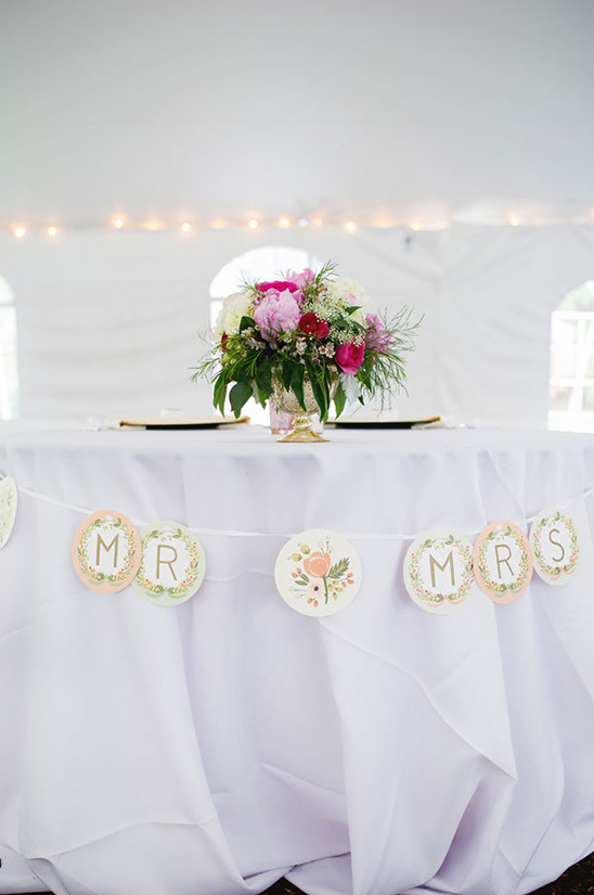 Wedding table with floral centerpiece and Mrs banner