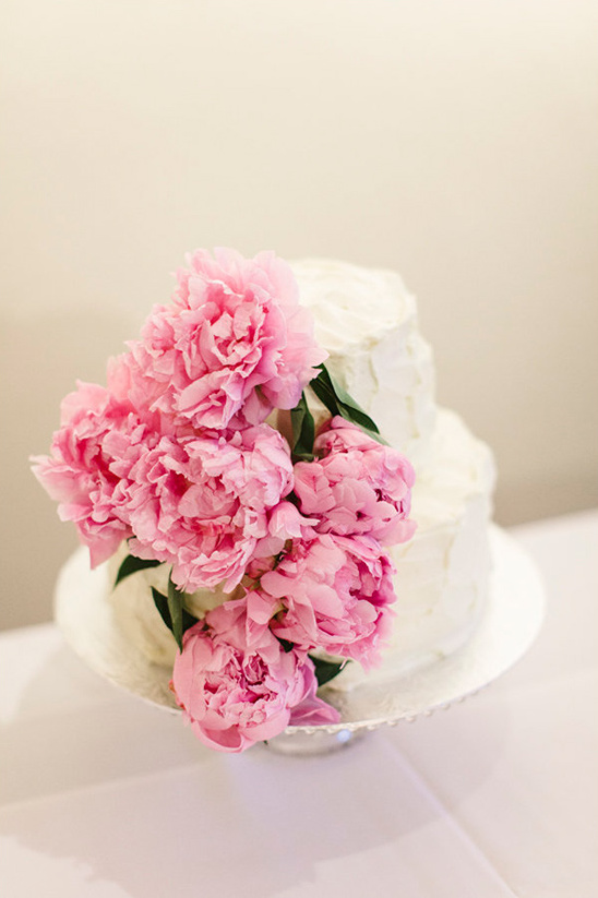 Wedding cake with pink peonies decoration on cake stand