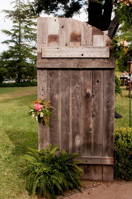 Rustic wooden door with flowers and ferns in garden