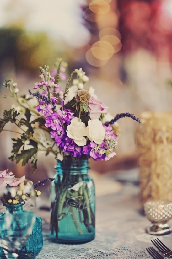 purple and white floral arrangements in blue mason jars
